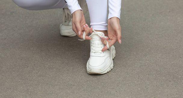 Closeup of young fit woman tying shoe laces - Fotoğraf, Görsel