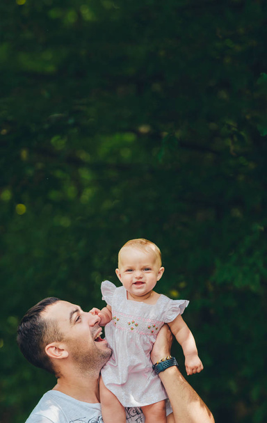 Father and baby daughter outdoors. Baby girl having fun with dad. - Foto, afbeelding