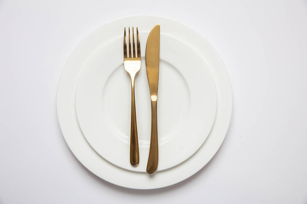 Ustawienia stołu, formalne. Złote sztućce na białym zestawie potraw, białe tło - Zdjęcie, obraz