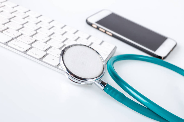 Stethoscope, phone and keyboard on white background, Stethoscope Concept of medicine and diagnostics. - Foto, Bild