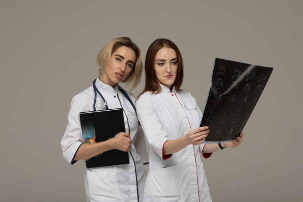 Successful team of medical doctors standing together on gray background. - Valokuva, kuva