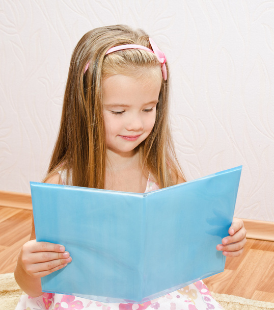 Cute smiling little girl reading a book - Photo, image