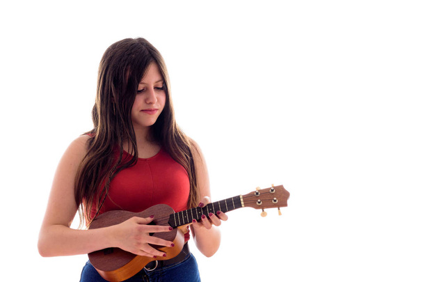 ウクレレを演奏する十代の少女、彼女の楽器で孤立した若いアーティスト - 写真・画像
