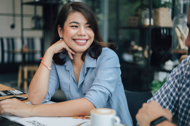 Femme asiatique en chemise bleue dans le café boire du café et parler w
 - Photo, image