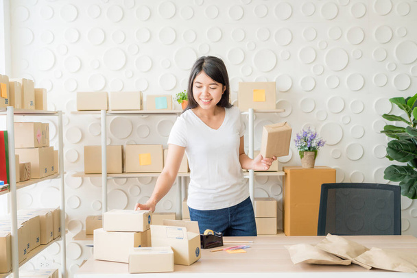 Asian Women business owner working at home with packing box on w - Foto, Imagem