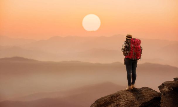 Žena v batohu stojící na kopci s krásnou přírodou a su - Fotografie, Obrázek