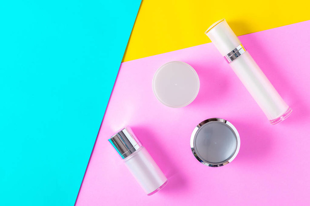 Top view of white cosmetic bottle containers on color background. - Fotó, kép