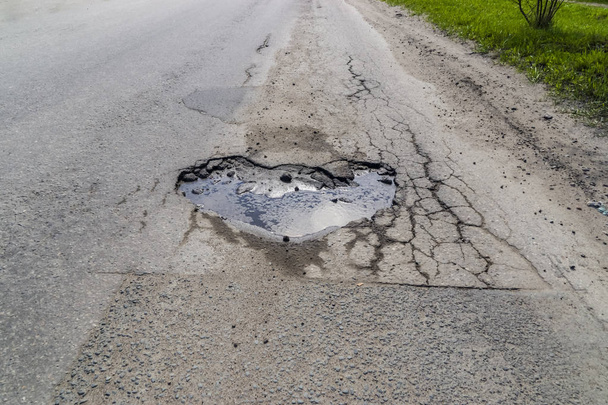 Sydämen muotoinen kuoppa tiellä asfaltti
 - Valokuva, kuva
