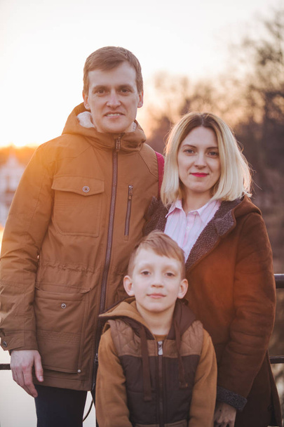 ritratto famiglia di tre in abito autunnale al tramonto
 - Foto, immagini