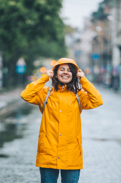 young pretty smiling woman portrait in raincoat with hood - Фото, зображення