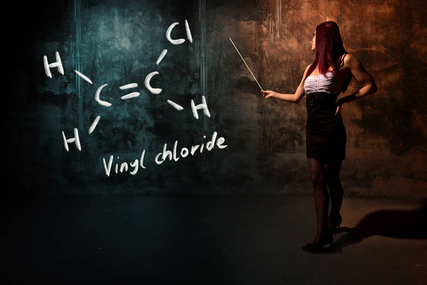 Seksikäs tyttö tai sihteeri tai naispuolinen opiskelija esittelee käsin tehty kemiallinen kaava vinyylikloridi
 - Valokuva, kuva