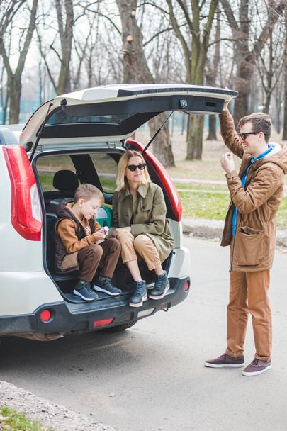 giovane famiglia imballaggio per i viaggi in auto. mettere borse nel bagagliaio
 - Foto, immagini