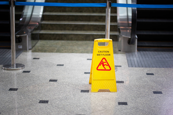 żółty znak ostrzegawczy z napisem na mokrej podłodze - Zdjęcie, obraz