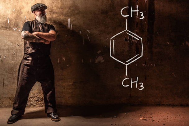 Hombre viejo barbudo que presenta fórmula química dibujada a mano de Xileno
 - Foto, imagen