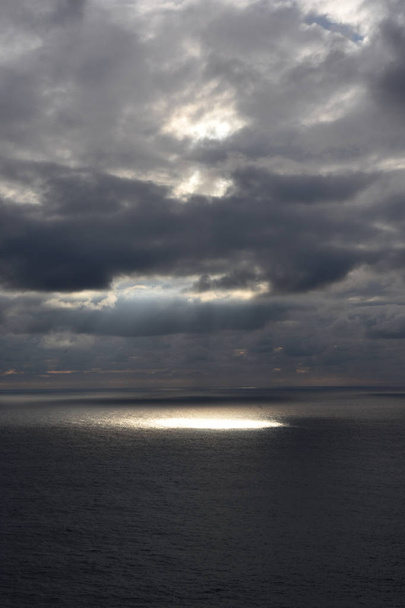 a sunbeam that sneaks through the clouds and goes to the sea in  - Foto, immagini
