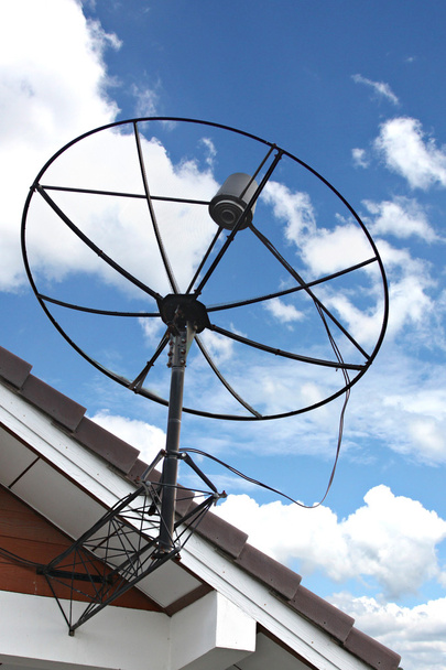 parabola antenna megragadt a tető a ház, a kék ég. - Fotó, kép