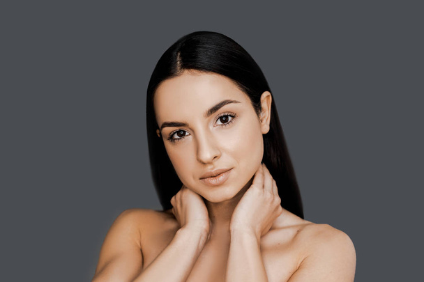 Portrait of beautiful brunet woman over the grey studio background, healthy skin and beauty procedure concept. Perfect skin and hair after cosmetology procedures in spa salon. Sensual, feminine. - Fotoğraf, Görsel