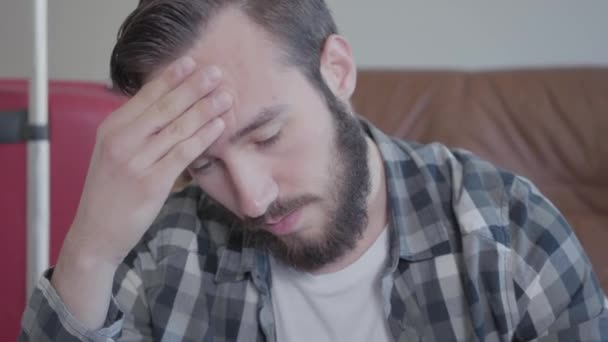 Close up portrait of a bearded pensive young man in a plaid shirt, video  - Imágenes, Vídeo
