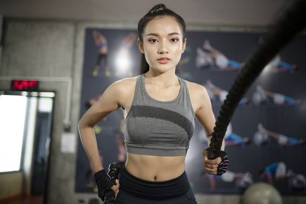 Donna con esercizio di corda da battaglia nella palestra fitness
 - Foto, immagini