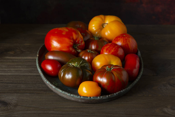 Ugly raf, kumato, heirloom  tomatoes on brass tray, homegrown and  fresh gathered. - Foto, imagen