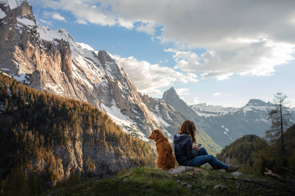 girl with a dog in the mountains. Autumn mood. Traveling with a pet. Nova Scotia Duck Tolling Retriever - Фото, изображение