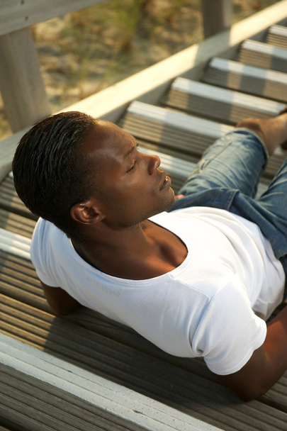 Portrait of a young man sitting alone outdoors - Φωτογραφία, εικόνα