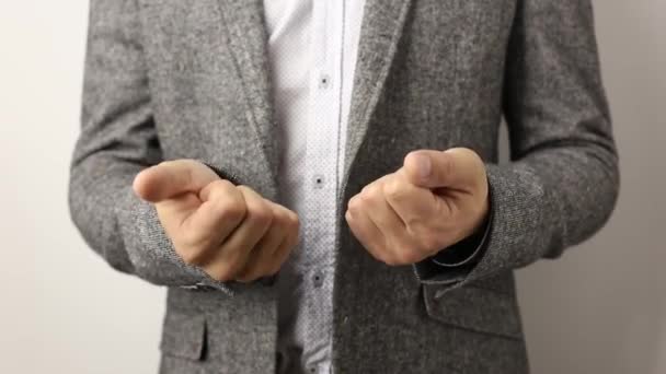 Homme caucasien solide en veste grise et chemise mouchetée sur fond blanc comptant lentement les doigts inflexibles jusqu'à dix
 - Séquence, vidéo