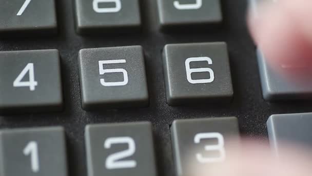 A woman punches numbers on an old calculator - Footage, Video