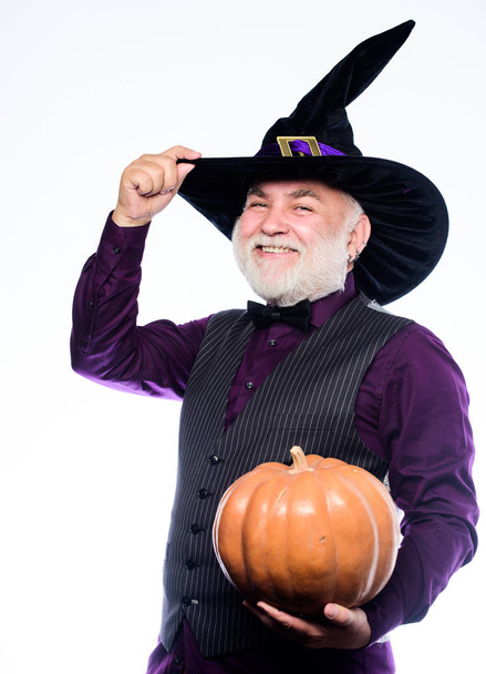 making jack o lantern. mature man magician in witch hat. bearded man ready for halloween party. evil wizard hold orange pumpkin. Stargazer in holiday costume. Traditional food. happy halloween - Φωτογραφία, εικόνα