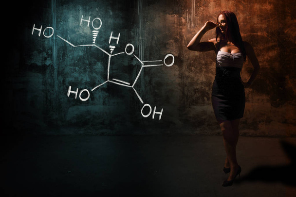 Seksowna dziewczyna lub Sekretarz lub studentka prezentująca ręcznie sporządzona formuła chemiczna witaminy C - Zdjęcie, obraz