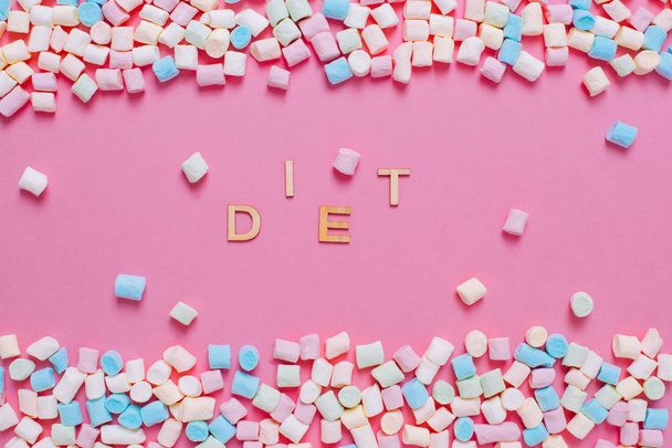 Dieta-kawałki liter na różowym tle pokryte białym i p - Zdjęcie, obraz
