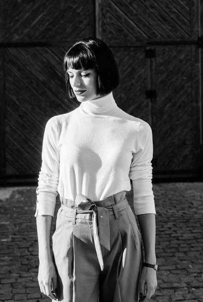 High waisted. Femininity and emphasize feminine figure. High waisted trousers keep returning to catwalk. Woman attractive brunette fashionable outfit. Girl makeup face wear loose high waisted pants - 写真・画像