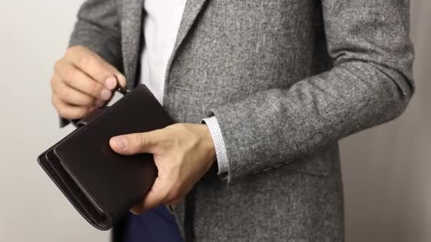 Συμπαγής άνθρωπος με γκρι μπουφάν σε λευκό φόντο παίρνει 300 δολάρια ΗΠΑ χαρτονομίσματα από το πορτοφόλι. Χαρτονομίσματα του ανθρώπου που μετράνε - Πλάνα, βίντεο