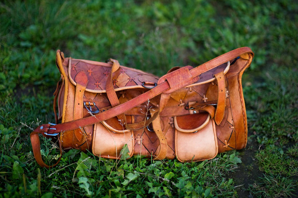 Bright orange leather bag on the grass on a summer evening. close-up - Zdjęcie, obraz