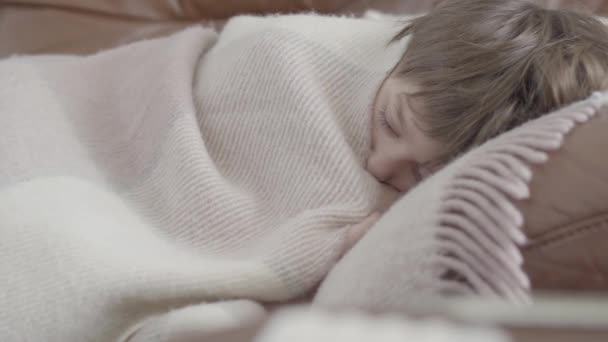 vidéo d'un garçon malade allongé sur un canapé recouvert d'une couverture à la maison
  - Séquence, vidéo