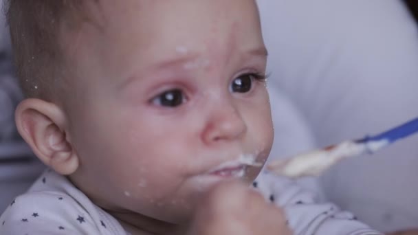 Mother feeding her baby son with porridge, close up - Кадри, відео