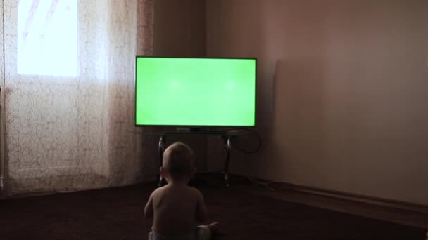 Child watching cartoon sitting on floor - Footage, Video