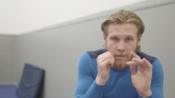 Portrait of confident bearded blond man slowly punching and stroking the air, showing his skills in the gym close up. Professional kickboxer showing fist and palm punches. Concept of martial arts - Footage, Video