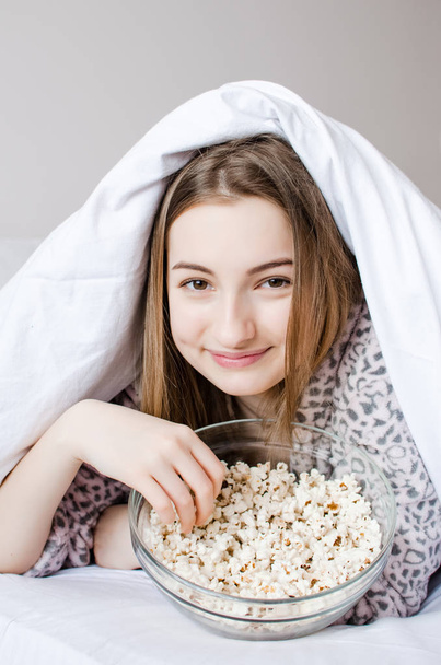 Красивая молодая женщина ест попкорн
 - Фото, изображение