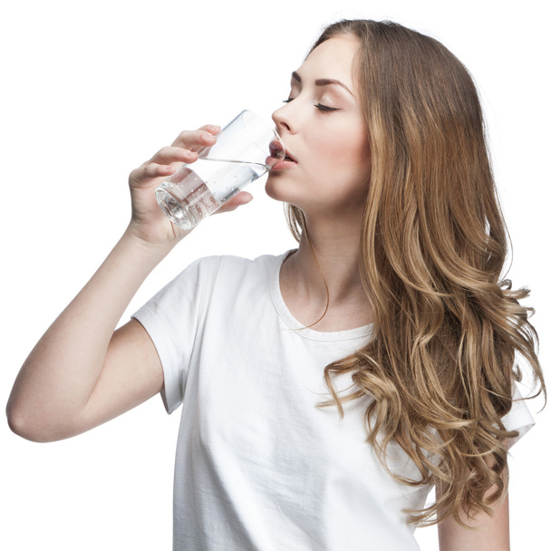 Young beautiful brunette woman drinking water - Fotó, kép