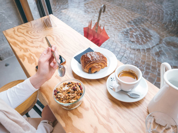 Yleiskustannukset nainen syö herkullista Aamiainen ranskalainen kahvila
 - Valokuva, kuva