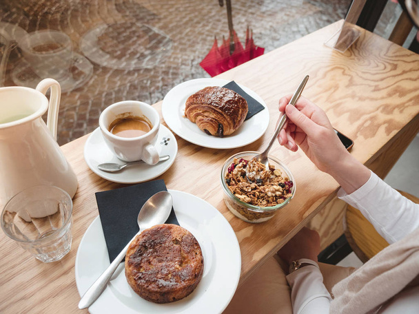 Overhead de mulher comer delicioso café da manhã no café francês
 - Foto, Imagem