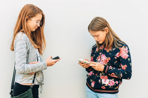 Groep schoolmeisjes spelen online game met smartphone - Foto, afbeelding