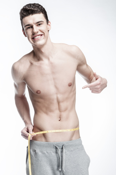 Young man measuring waist - Fotó, kép