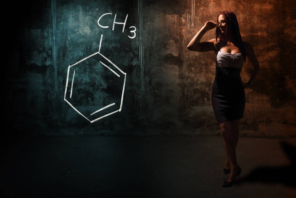 Menina sexy ou secretária ou estudante do sexo feminino apresentando fórmula química desenhada à mão de tolueno
 - Foto, Imagem