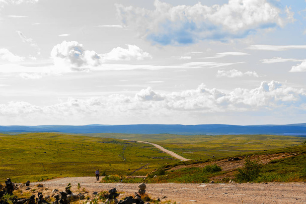 Srebrne niebo nad Tundra drogowego. Murmańsk Ziemia jest piękne i urzeka. Drogi idą w chmurach przez wzgórza - Zdjęcie, obraz