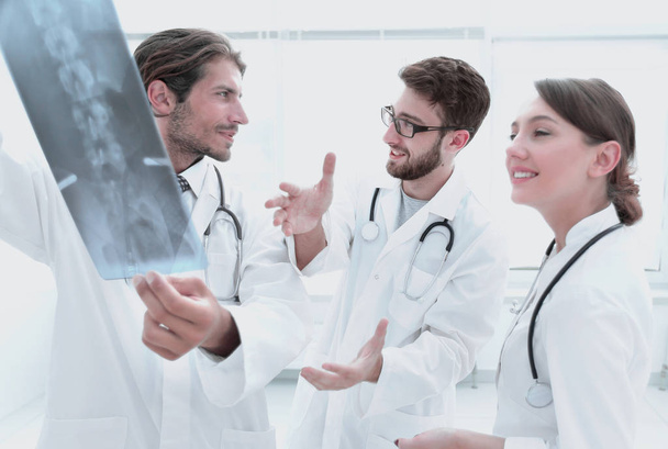 Drei selbstbewusste Ärzte untersuchen ein Röntgenbild - Foto, Bild