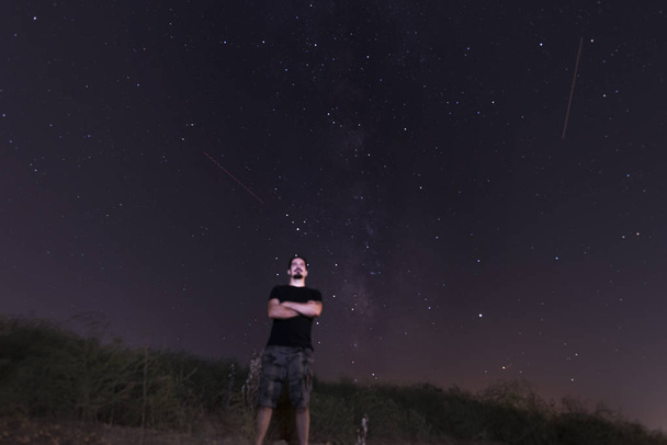 Mann in der Nacht mit Milchstraße im Hintergrund - Foto, Bild