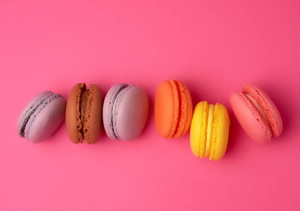 kleurrijke gebakken Macarons amandelmeel op een roze achtergrond - Foto, afbeelding