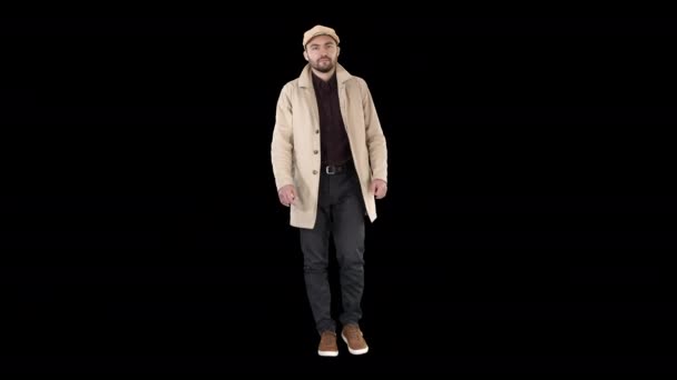 Homem com barba escura em caminhadas de casaco de trincheira leve, Canal Alpha - Filmagem, Vídeo